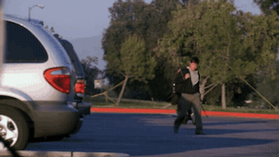 Person Walking In Parking Lot With Silver Minivan GIF
