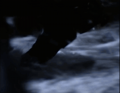 Person Walking Through Dark Room With Smoke GIF