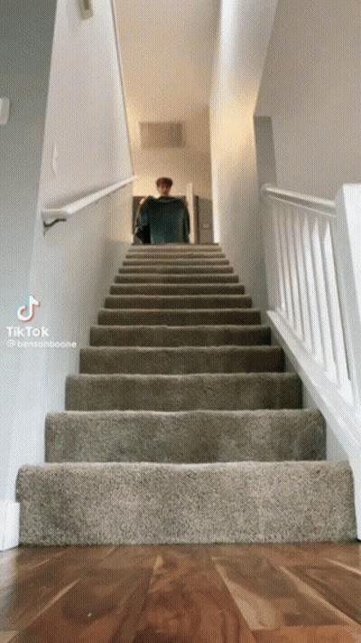 Person Walking Up Stairs With White Railing GIF