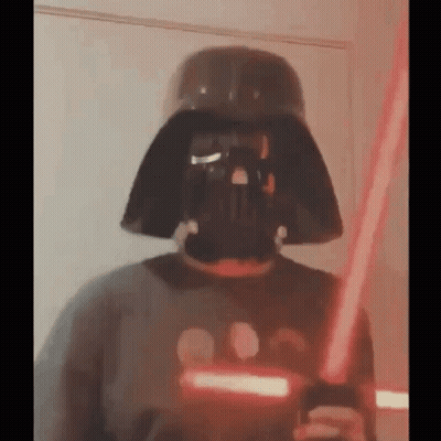 Person Wearing Darth Vader Mask Holding Lightsaber GIF