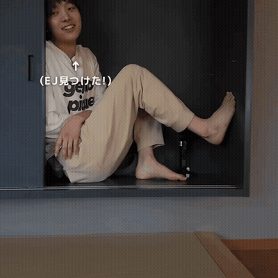 Person Wearing 'EJ' Shirt Sitting In Closet GIF