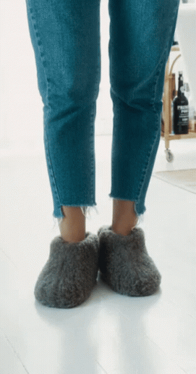 Person Wearing Grey Slippers With Evian Bottle GIF