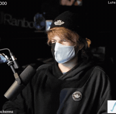 Person Wearing Mask And Beanie At Microphone GIF