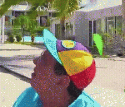 Person Wearing Rainbow Hat With Yellow Sun GIF