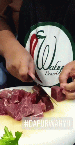 Person Wearing Wahy Brand Apron Cutting Meat GIF