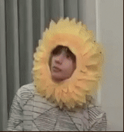 Person Wearing Yellow Sunflower Hat GIF