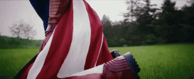 Person With American Flag Over Feet In Field GIF