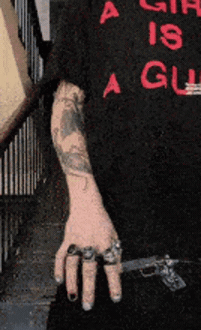 Person With Arm Tattoo Holding Gun GIF
