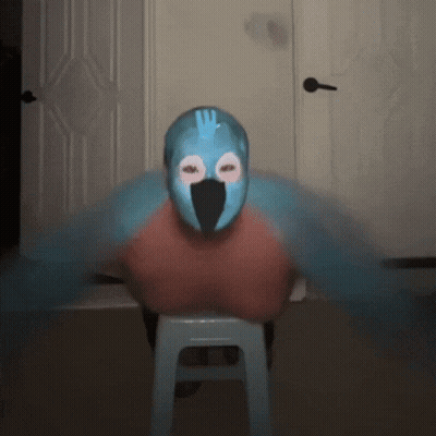 Person With Bird Mask Sitting On Blue Stool GIF