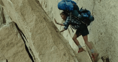 Person With Blue Backpack Climbing Rock Wall GIF