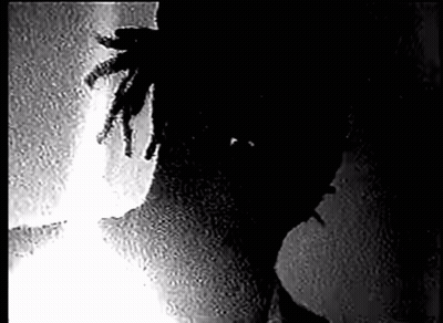 Person With Dreadlocks Standing Next To Wall GIF