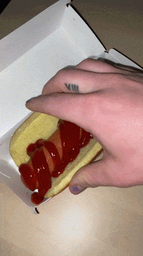 Person With Finger Tattoo Holding Hot Dog GIF