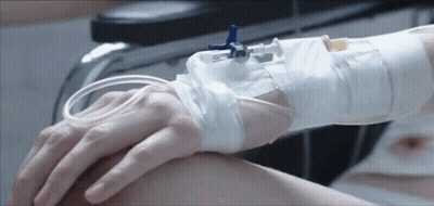 Person With IV Holding Hand In Hospital Bed GIF