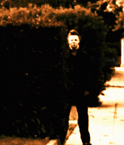 Person With Mask Walking Down Sidewalk GIF