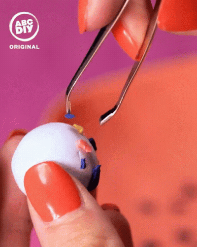 Person With Orange Nails Holding Toy GIF