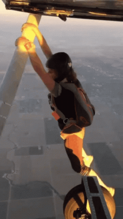 Person With Parachute Hanging From Plane GIF