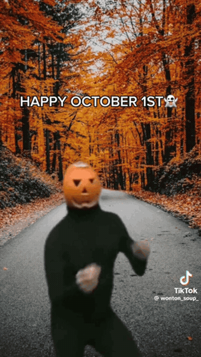 Person With Pumpkin Head Dancing On Autumn Road GIF
