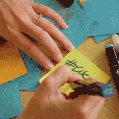 Person With Ring Writing #Cik On Yellow Sticky Note GIF