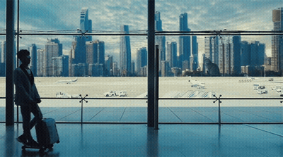 Person With Suitcase Looking Out Window At City GIF