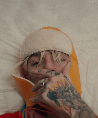 Person With Tattoo Covering Mouth With Hand GIF