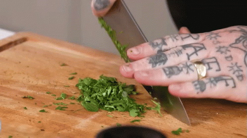 Person With Tattoos Cutting Greens GIF