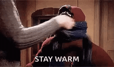 Person Wrapping Scarf Around Head Saying Stay Warm GIF