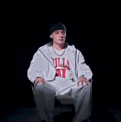 Peso Pluma Sitting Wearing White Bulls Jersey GIF