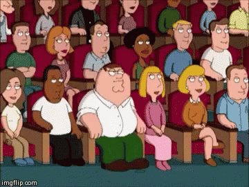 Peter Griffin Is Sitting In The Middle Of A Crowd Of People In A Theater . GIF
