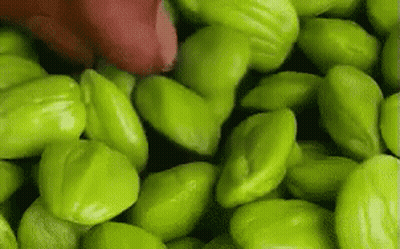 Pile Of Green Beans With Red Object GIF