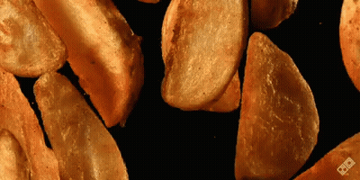 Pile Of Potato Wedges On Black Surface GIF