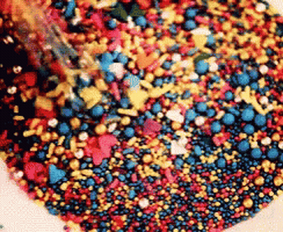 Pile Of Red Yellow And Blue Sprinkles GIF