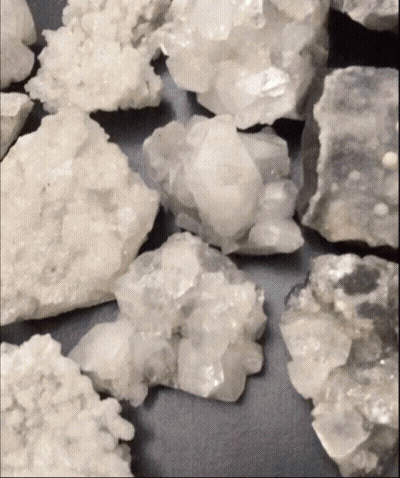 Pile Of White Rocks On Black Background GIF