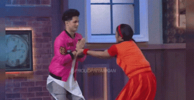 Pink Jacket Man And Red Dress Woman Dancing By Clock GIF