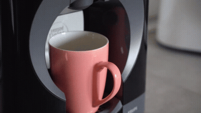 Pink Nescafe Cup Being Poured Into Krups Coffee Maker GIF