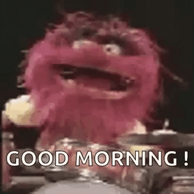 Pink Puppet Holding Drum Saying Good Morning GIF