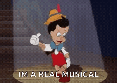 Pinocchio Is Giving A Thumbs Up And Saying `` I 'M A Real Musical '' While Standing On A Stage . GIF