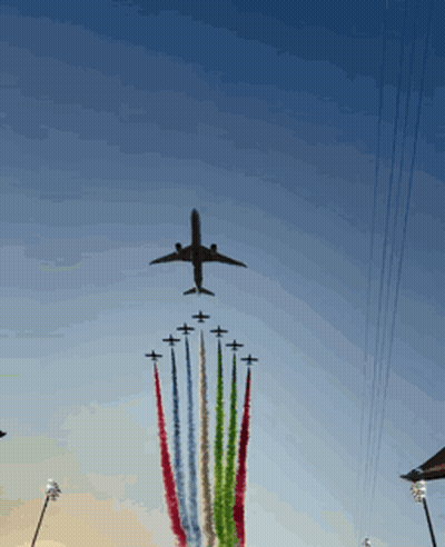 Plane Flying Over Row Of Planes With Smoke Trails GIF