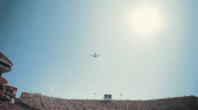 Plane Flying Over Stadium With Scoreboard GIF
