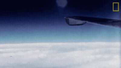 Plane Flying Through Clouds With National Geographic Logo GIF