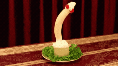 Plate Of Food That Looks Like A Penis With Red Curtain GIF