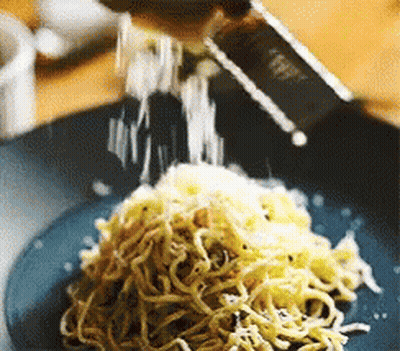 Plate Of Noodles With Cheese Being Grated GIF