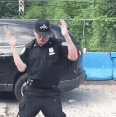 Police Officer Dancing In Front Of Car GIF