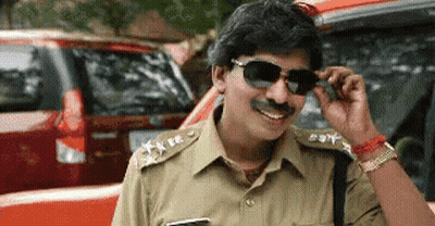 Police Officer In Sunglasses And Fake Mustache Smiling In Front Of Red Car GIF