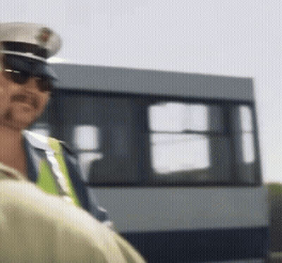 Police Officer In Sunglasses And Hat In Front Of Bus GIF