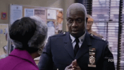 Police Officer Shaking Hands With Woman In Purple Coat GIF