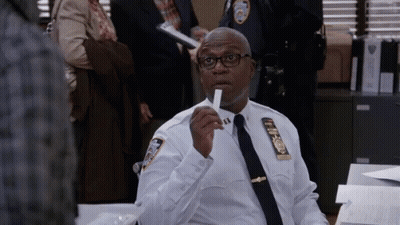 Police Officer Sitting At Desk Holding Paper GIF