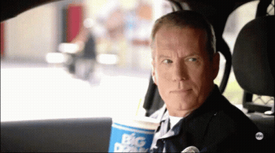 Police Officer Sitting In Car Holding Big Dipper Cup GIF