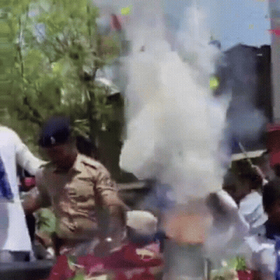 Police Officer Standing In Front Of Crowd With Smoke GIF
