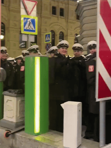 Police Officers Standing Next To Green Pole GIF