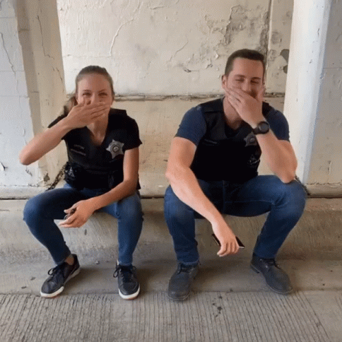 Police Uniforms Sitting On Ground Covering Mouths GIF